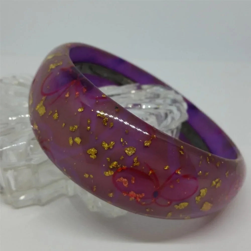 Lucite style purple bangle bracelet with glitter flakes and butterflies